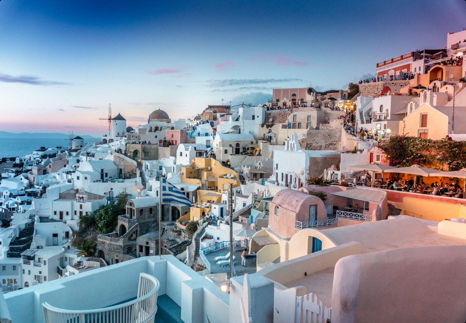 White-washed clifftop village of Santorini glowing at sunset above the Aegean Sea
